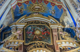 <center>Saint-Nicolas-de-Véroce</center>Le Dieu transcendant et abstrait est représenté par un triangle avec un œil en son centre au sommet de la pyramide. Il est entouré d'un tourbillon d’anges et de nuages. Dans le décor baroque, les nuages signifient que la lumière divine est cachée aux yeux des hommes comme par des nuées. Les anges percent les nuages pour apporter cette lumière sur terre. Sous le dais, la Colombe représente le Saint-Esprit, soit le souffle de Dieu qui fait vivre les chrétiens.