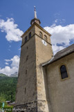 <center>Eglise de la Sainte Trinité des Contamines Montjoie</center>Le clocher carré de l'église, doté d'une flèche vers 1850, a pour base une tour de l'ancien château détruit qui gardait la frontière (au col du Bonhomme) avec la Tarentaise.
