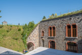 <center>Albertville : Fort du Mont.</center> Le casernement des sous-officiers. L’artillerie de l’époque, en progrès constant, projette des obus destructeurs. Les bâtiments maçonnés sont donc dissimulés sous d’épais matelas de terre. L’explosion d’un projectile forme un cratère mais ne perce pas la voûte de la casemate.