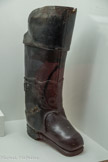 <center>Conflans : Musée d’Art et d’Histoire.</center> Bottes de postillons.
Cuir, métal, bois, fibre et crin. XVIIIe siècle - Lyon - Dussaussoy bottier, 2,85 kg par botte
Le postillon est chargé de conduire les voyageurs au galop, puis de ramener le cheval à vide à son relais d'origine tandis que le voyageur poursuit sa route.
Ses lourdes bottes lui évitent d'avoir la jambe écrasée par le poids du cheval en cas de chute.
Les bottes restent fixées à la selle. Charles Perrault fait référence à ce type de bottes dans l'histoire du « petit Poucet» sept lieues représentent environ 28 km soit la distance entre deux relais de poste, d'où l'appellation de « bottes de sept lieues ».
Un cheval qui quitte son relais est toujours accompagné d’un postillon. En France, on compte 4000 postillons vers 1760 et 8000 vers 1850. Ceux-ci sont vêtus d’un uniforme qui change de couleur avec le régime politique : bleu roi sous la monarchie, vert sous l'Empire.
Le postillon monte directement sur le cheval pour diriger l’attelage.
En 1830, le postillon prend place sur un siège à l’avant de la voiture, à côté du conducteur (qui ne conduit pas). Avant le départ, le conducteur vérifie le bon état de la voiture, accueille les voyageurs, ferme les portes. Il sonne le départ avec sa trompette. En chemin, il hurle ses ordres au postillon. Il est capable de réparer des dégâts mineurs. A l'arrêt, c'est lui qui immobilise la voiture avec la mécanique à enrayer, le frein et un sabot.