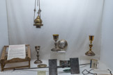 <center>Conflans : Musée d’Art et d’Histoire.</center> 1 Calice - Argent - 2ndmoitié 19e siècle — Lyon — Maison Favier – Calice 2e quart 19e siècle — F. RABUT.
2 Patène - Argent - Fin 18e siècle — déb 19e siècle – Paris.
3 Pupitre d'autel — 1659 — Beaufortain — Jean DUC.
4 Missel — 1857 — Arevy & Cornillac — Chatillon-sur-Seine
5 Encensoir — Cuivre, laiton. 19e siècle. Moule à hosties. Fer, Beaufort, XIXe siècle. Inscription : Gilliard à Beaufort.

L’Eglise rythme la semaine.
Depuis la fin du Moyen Age, la pièce maîtresse du culte est la messe. L’office du dimanche et des jours chômés, les vêpres,...
La messe a pour origine le dernier repas de Jésus avec sas disciples avant sa mort i la cène. Pondant ce dernier repas, Jésus prit du pain, le bénit, la rompit et ta donna à ses apôtres an disant s Prenez, ceci est mon corps », puis prenant une coupe, il rendit grâce et la leur donna en disant s ceci est mon sang e.
Ainsi, la messe prit pour nom, chronologiquement : fraction du pain ou repas du seigneur ; eucharistie (action de grâce) ; sacrifice ; messe.
Lors de la messe, l'Eucharistie (action de grâce) commémore la cène avec deux objets indispensables : le calice et la patène. Le calice reçoit le vin. La patène l'hostie (pain).
A l'origine, il faut voir dans ces objets qui sont les plus importants parmi ceux qui décorent l'autel, un simple « vase à boire » et un « plat », c'est-à-dire les objets de la vie quotidienne. Dans les débuts du christianisme, l'Eucharistie était un repas célébré dans les maisons privées avec les éléments les plus communs. Chaque prêtre a son propre calice, qui revient à la paroisse quand il décède. La croix sur le calice est le point de repère de la face qui doit être du côté du célébrant.
Autres objets se trouvant sur l'autel : le livre et le pupitre.
Le missel est un livre liturgique contenant toutes les informations pour suivre une messe. Il en existe deux modèles : le missel d'autel destiné à l'usage du célébrant et pouvant être déposé sur un pupitre, et le missel paroissien, destiné au fidèle. Les missels contiennent la plus grande partie de l’Écriture Sainte ; comme ils donnent aussi le texte des prières et des chants de l’Église, ils constituent un aliment privilégié pour la vie chrétienne. Sans pouvoir participer à la messe tous les jours, les fidèles ont la possibilité de lire et de méditer chaque jour le « menu » de l’Église.
Au cours de la messe, le célébrant encense la croix, l'autel, le livre des évangiles, le pain et le vin. Pour cela il utilise l'encensoir (5), un brûle-parfum métallique dont le couvercle est articulé par quatre chaînes qui permettent aussi de le balancer. La fumée de l'encens qui monte vers le ciel symbolise les prières que les fidèles adressent à Dieu.