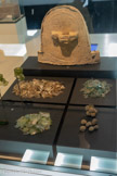 <center>MuséAl</center>La boutique du verrier.
Le long du cardo, des fouilles ont révélé les vestiges de la boutique d'un marchand de verre, de 22,50 m2. Son sol était recouvert d'une couche de fragments de verre. A partir d'eux, on a pu déterminer la vaisselle qui y était vendue : pour les 3/4 des vases à présenter (coupes ou assiettes), les vases à boire et ceux à verser étant les deux autres groupes prépondérants, mais aussi quelques raretés de provenance lointaine. <br> Fragments de verre
 2e siècle après Jésus-Christ.
 Boutique du forum, Alba-la-Romaine.
Fragments de verre, calcinés à la suite d'un incendie de la boutique installé le long du cardo maximus. 
L'étude de ces fragments a permis de reconnaître des formes et des techniques qui attestent de production régionale mais aussi orientale Le marchand installé dans cette boutique vendait essentiellement du verre et proposait surtout des vases à présenter des aliments (coupes et assiettes) et des vases à boire (gobelets).
<br> Boules. Fritte.  Alba, boutique du forum. Les boules de fritte bleue, appelée aussi « bleu égyptien », sont des pigments de synthèse mélangeant sel de cuivre, calcium et silice. Ont-elles été employées pour teinter les verres ?  Ou servaient-elles à la réalisation de peintures murales ?