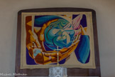 <center>Vogüé</center>Cette tapisserie a été inaugurée le 19 novembre 1989. Elle a été conçue par un artiste des environs : Gilbert Alignet, avec la collaboration d’une petite équipe de Vogüéens.
La réalisation complète est l’œuvre des gens du pays : femmes et hommes de bonne volonté qui ont travaillé sur quatre métiers installés dans deux petits ateliers. Le motif est fait au point de Hongrie et au point plat. Il a fallu 12kgs de laine.
Signification :
Des mains partagent le pain.
Des mains offrent le monde : le monde vu de loin, comme d’un satellite. Il est en évolution
L’ensemble est recouvert par les ailes de l’Esprit qui fait monter le tout v Christ.
Les couleurs :
Le BRUN représente l’Humanité (les mains, la présentation extérieure du pain.)
BLEU et VERT, signe de la transformation, de l’évolution.
ROSE : signe du Divin