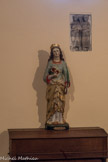 CORNILLON. <br> A droite de la statue de ste Philomène, un fragment est fixé au mur de la chapelle. Il est bien conservé en haut et en bas mais pas sur les côtés et mesure dans son état actuel 52 cm sur 29. Il est en marbre blanc veiné de gris. Deux apôtres debout, vêtus du pallium, regardent vers la gauche. Celui de gauche, imberbe, tient dans sa main gauche, qui sort des deux plis du manteau, le rouleau des Ecritures. Il a perdu son bras droit emporté par la cassure. L'autre regarde dans la même direction, il tient aussi un volumen, cette fois déployé, de la main gauche, et lève la droite en signe d'acclamation. On remarquera l'importance donnée à cette main levée aux doigts rigides. On devine une barbe sur ce visage très usé. Un pli du pallium long, courbe, en relief marqué, traverse la poitrine des deux hommes comme une écharpe, tandis que les plis tombants de la draperie sont esquissés à grands traits. Ces deux apôtres acclament une représentation - Jésus, la Croix ou une Orante - placée devant eux.