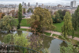 <center>Le parc des Buttes-Chaumont  </center>ue vers le Nord et dans l’axe de l’avenue de Laumière à l’angle avec la Mairie du XIXe, les 4 tours de l’avenue de Flandre ( M. Schulz Van Treeck Arch. 1970-1978) situées au delà du bassin de la Villette .