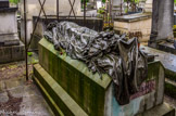 <center>Le cimetière du Père Lachaise </center> Tombe d'Auguste Blanqui. Décidemment obsédé par le corps masculin, Jules Dalou, a réitéré pour le gisant de Blanqui ce qu’il avait attribué à Victor Noir : une virilité triomphante.
Auguste Blanqui 1805-1881. Homme politique français.  Révolutionnaire, Blanqui s’est battu pour des idées neuves à son époque notamment pour le suffrage universel (Un homme, une voix), pour l'égalité homme/femme, la suppression du travail des enfants etc. Il doit son surnom l’Enfermé au fait qu'il passa la plus grande partie de son existence (près de 37 années !…) en prison. Il est à l'origine du blanquisme.Il parcourt  la France et diffuse ses idées dans son journal « Ni Dieu ni maître ».
Après avoir prononcé un discours au cours d'un meeting révolutionnaire à Paris, fin 1880, il meurt d’une crise d'apoplexie le 1er janvier 1881. Ses obsèques sont suivies par cent mille personnes.