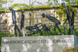 <center>Le cimetière du Père Lachaise </center> Monument de Buna-Monowitz-Auschwitz III. Sur un socle de granit, le sculpteur Louis Mitelberg, dit Tim (ancien Français libre) a disposé cinq figures longilignes en bronze. Leurs silhouettes affaissées témoignent de la souffrance et de l’épuisement des déportés. Le corps transporté dans la brouette rappelle la forte mortalité dans le camp de concentration de Buna-Monowitz. La lumière qui passe au travers des personnages et dessine les rayures de leur tenue de déportés souligne la fragilité de leur existence et leur situation de morts en sursis.
Ouvert fin octobre 1941 à proximité des usines Buna fabricant du caoutchouc synthétique pour l’entreprise IG-Farben, le camp de Monowitz est rattaché à celui d’Auschwitz. En novembre 1943, Monowitz devient un camp autonome sous le nom d’Auschwitz III, auquel sont rattachés près d’une quarantaine de Kommandos travaillant pour l’industrie allemande implantée en Haute-Silésie. Les détenus sont pour la plupart des Juifs. Les conditions de travail sont extrêmement dures et des sélections envoient dans les chambres à gaz d’Auschwitz-Birkenau ceux qui s’épuisent le plus vite.