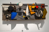 <center>Jean Tinguely</center>Méta-Kandinsky I 1956 (Autre titre : Wundermaschine)
Éléments en tôle, bois, essieux, courroies sur panneau en bois, moteur électrique.
Museum Tinguely, Bâle/un engagement culturel de Roche Ancienne collection Pontus Hulten. <br>
Le noyau des collections du Museum Tinguely est constitué de la donation d'une cinquantaine de sculptures de l'artiste par Niki de Saint Phalle. À cela s'ajoutent principalement des œuvres provenant de l'ancienne collection de Pontus Hulten, dont ce relief. À partir de 1955, Tinguely intègre la couleur dans ses reliefs, réalisés seulement en noir et blanc à ses débuts. Il rend ici hommage à Kandinsky, artiste majeur de l'avant-garde, par l'utilisation d'éléments de tôle de diverses couleurs. Le mot « méta » - qui aurait été lancé par Pontus Hulten - marque une volonté de dépassement. Cette « machine à merveilles », autre titre de cette œuvre, est actionnée par un mécanisme bien visible, ce qui est encore rare dans les réalisations de Tinguely des années 1950.