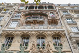 <center>L’immeuble Lavirotte. </center> La devanture de l’immeuble Lavirotte se dresse dans l’asymétrie la plus totale, avec ses lignes courbes irrégulières. Si l’on étudie bien sa construction, on remarque que les quatre travées de l’édifice sont parfaitement déséquilibrées : au 3e étage, on aperçoit une fenêtre ovale légèrement avancée allant complètement à contre-courant des autres fenêtres plutôt rectangulaires et davantage en retrait