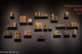 <center>Shourouk Rhaiem</center>(Paris, née en 1980)
Cleopatra's Kiosk 2025
Installation d’objets divers recouverts de cristaux Swarovsk Paris, collection de l’artiste
Fascinée par la vie idéalisée véhiculée par la publicité des années 1980 et 1990, Shourouk Rhaiem détourne le concept marketing voulant qu’un simple produit domestique puisse améliorer la vie de la ménagère pour l’exploiter et le pousser à son paroxysme. Elle allie avec humour les produits de consommation ordinaires au glamour des paillettes de la pop culture de ces années, en sélectionnant des marchandises commercialisées sous le nom de Cléopâtre qu’elle recouvre entièrement de cristaux Swarovski.