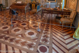 <center>Grand cabinet </center>A droite, Bureau plat en placage de palissandre et de bois de rose, orné de bronzes ciselés et dorés, couvert d’un marocain rouge. Les quatre pieds du bureau adoptent les courbes et contrecourbes habituelles de la Rocaille mais la ligne générale du meuble demeure sage. La ceinture abrite trois tiroirs dont les deux latéraux accusent une forme en virgule légèrement saillante. Les appliques en bronze ciselé et doré ornant les arêtes du plateau, des pieds, ainsi que les poignées et entrées de serrure des tiroirs, sont particulièrement remarquable.  1700-1799. Antoine Robert Gaudreau ou Gaudreaux (vers 1680-1751), attaché au service du Garde-Meuble de la Couronne en 1726, installe son atelier rue Princesse (actuel 6e arrondissement de Paris) à l’écart des quartiers habituels des ébénistes tel que le faubourg Saint-Antoine. Il collabore avec les sculpteurs Caffieri ou encore les frères Slodtz, conférant à ses oeuvres un caractère remarquable grâce à la qualité des ornements de bronze.