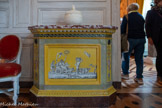 <center>Petite antichambre</center>Poêle de chauffage. 1775-1825.  Poêle en faïence de couleur, dominante de jaune et bordure verte, avec pour motif central une scène à l'antique d'un char tiré par des panthères. Frises d'oves et de vagues couronnant le corps du poële, surmontées d'un plateau en marbre rouge de Caunes.