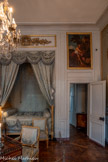 <center>Chambre de Monsieur Thierry de Ville-d'Avray</center>Tableau : David jouant de la harpe. La Fosse, Charles de. 1700. Tableau peint à l’huile sur toile fixée sur une support en bois, représentant David jouant de la harpe, la tête de Goliath à ses pieds devant un pilier et un arbre. Oeuvre réalisée en pendant de Sainte Cécile jouant de la harpe. <br>Après la porte, la garde-robe. Encoignure néoclassique aux angles abattus et vantail unique. Elle repose sur des pieds en plinthe garnis d'écoinçons en façade. Le décor est composé par une marqueterie de frisage. Le fond sombre rehausse les tables plus claires des angles ainsi que le motif en étoile sur le vantail. L'ensemble est sobrement souligné de bronzes dorés pour l'entrée de serrure et les décors de pseudo-chapiteaux à triglyphes en haut des montants. Le plateau est en marbre gris veiné blanc..