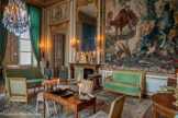 <center>Chambre d'apparat de Mme Thierry de Ville d'Avray.</center>A gauche, Canapé droit en bois doré, reposant sur huit pieds fuselés et cannelés surmontés d’un dé de raccordement à fleurette. La ceinture est ornée d’une frise à feuille d’eau. Les consoles d’accotoirs amorcent un léger retrait, ornées de feuilles d’acanthe et de rais de cœur. L’accotoir lui-même reprend les mêmes motifs, dans un double mouvement d’enroulement qui le réunit au dossier dont la traverse supérieure est droite. Dans les angles, les dés de raccordement surmontés de petits culots d’acanthe tiennent lieu de pommes. Le canapé est garni à carreau et couvert d’un velours uni tons vert canard.. Canapé néoclassique appartenant à l'ameublement des salons tel qu'il se développe au XVIIIe siècle.