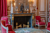 <center>Chambre sur cour.</center>Paire de chenets en bronze doré de style Louis XVI, constitués d'un tore orné de motifs floraux sous un fût de colonne circulaire cannelé supportant une cassolette à têtes de boucs et femmes reliés par une guirlande. Le fût est parcouru par une frise de rinceaux se poursuivant sur la traverse le reliant à une second base, formée d'un fût cannelé et d'un dé à rosace sur lequel est assis un lion.