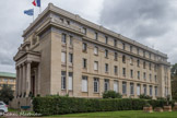 <center>Cité internationale universitaire de Paris. </center> Fondation hellénique. En 1926, André Honnorat invita le gouvernement hellénique à édifier un foyer national à la Cité internationale. Mais les finances de l’État grec avaient été malmenées par dix ans de guerre contre l’empire Ottoman. La Fondation hellénique a donc vu le jour grâce à une souscription panhellénique qui a réunit des Grecs de Grèce et de la diaspora grecque. La mobilisation des milieux francophiles et de l’ambassadeur de Grèce en France, Nicolaos Politis, a été décisive pour lever les fonds nécessaires. La construction de la fondation a démarré en 1931. Signé par l’architecte Nikolaos Zahos, le bâtiment rend hommage aux architectures de la Grèce antique. A l’extérieur bien sûr, avec son portique évoquant l’Acropole et ses façades ornées de frises. Mais aussi à l’intérieur, avec son magnifique hall à colonnes, pavé de mosaïque et baigné de lumière blanche. La maison a été inaugurée le 23 décembre 1932.