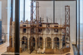 <center>Musée des Arts et Métiers.</center> Immeuble en construction rue de Rivoli. 
En 1818, l'entrepreneur Émile Desplanques construit rue de Rivoli, face aux Tuileries, un immeuble dont la façade reprend les prescriptions sévères édictées en 1802 lors du percement de la rue. L’enveloppe est en pierre de taille mais les planchers sont armés de métal ; la locomobile rythme l’avancement du chantier en facilitant les mouvements de matériaux.
Un projet de longue haleine.
La rue de Rivoli est née de la volonté de Bonaparte d’embellir les abords des palais des Tuileries et du Louvre. Le règlement des architectes Percier et Fontaine prévoit un alignement majestueux et une galerie à arcades pour permettre la circulation aisée des piétons.