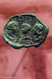 <center>Plomb de douane</center> Il est orné de trois têtes radiées. L'inscription GIRBA FELIX indiquerait que la marchandise scellée par ce plomb venait de Djerba (Tunisie). Plomb. IIIe s.