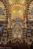<center>Notre-Dame de la Garde</center>Les piles sont en marbre blanc de Carrare et en marbre rouge de Brignoles, mais les arcs du plafond sont en stuc peint car la carrière de Brignoles était épuisée quand on commença la voûte. Les bancs sont de 1886.