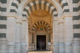<center>Notre-Dame de la Garde</center>Entrée de l'église. Le tympan de la porte principale est orné d'une mosaïque représentant l'Assomption de la Vierge d'après un tableau de Faivre-Duffer.
