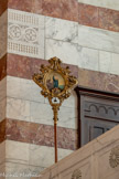 <center>Transept droit du choeur. </center>Le tintinnabule représentant une Vierge à l'Enfant, avec au fond, Notre-Dame de la Garde. Le tintinnabule est une clochette sur un support portatif et constitue, avec l'ombrellino, l'un des emblèmes distinctifs des basiliques. Lorsque, le 10 juin 187, Notre-Dame de la Garde a été érigée en basilique mineure, deux objets lui ont été offerts par le pape Léon XIII : le tintinnabule et l'ombrellino.