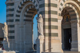 <center>Notre-Dame de la Garde</center>Devant le porche de la basilique, on trouve deux statues en marbre, les deux ayant été réalisées par Joseph Marius Ramus..