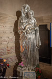 <center>Entrée de la crypte.</center>On y trouve une copie de la statue de Chanuel, qui se trouve dans le choeur,  beaucoup plus légère, et qui est portée en procession le soir du 14 août. Les personnages ne sont pas couronnés.