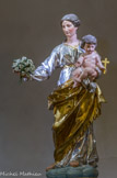 <center>Les 5 statues de Notre-Dame de la Garde.</center>La Vierge au bouquet. Le culte reprit en 1807. Escaramagne achète aux enchères une statue en bois de la Vierge à l’enfant du XVIIIe siècle qui provenait d’un couvent de religieux de Picpus, couvent qui se trouvait près du palais de justice mais démoli pendant la Révolution. Il l'offrit au sanctuaire. Le sceptre que tenait la Vierge, disparu sous la Révolution, est remplacé par un bouquet de fleurs, d'où le nom de la statue de « Vierge au bouquet ». Le samedi 4 avril, à huit heures du matin, elle est solennellement transportée sur le site par des hommes vêtus en lévites et pieds nus selon l'antique usage accompagnés par le curé de la Major, M. Jaubert.