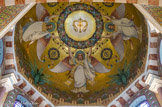 <center>Mosaïques de la grande coupole.</center>Quatre anges s'élèvent de la terre vers le ciel en soutenant une grosse couronne de fleurs, en particulier, de roses : symboliquement, ils nous invitent ainsi à prier le rosaire ou le chapelet. D’ailleurs, sous la couronne de fleurs, entre les mains des anges, on a représenté des grains multicolores de rosaire ou de chapelet. Au centre, la Vierge est représentée par son monogramme.