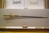 <center>Le musée Napoléon Ier.</center> Epée du sacre de 1801 issue de la manufacture d'armes de Versailles, autrefois ornée du diamant Le Régent.