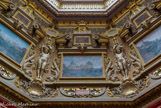 <center>Le château de Chantilly. </center> La Tribune. Cette salle doit sans doute son nom à la tribune de la Galerie des Offices à Florence, aménagée dans les années 1580 par Bernardo Buontalenti. Elle en possède la même forme hexagonale et les mêmes tentures rouges, ici du velours orné de passementeries d'or. Surplombée d'une verrière permettant là aussi un éclairage zénithal, elle est décorée, dans la partie haute, de huit tableaux commandés au peintre prix de Rome Armand Bernard. Ils illustrent les lieux de vie du duc d'Aumale : le Palais-Royal où il naît, le lycée Henri-IV où il a fait ses études, le château de Villers-Cotterêts, où il a passé une partie de son enfance, les châteaux d'Aumale et de Guise, qui appartenaient à sa famille, la résidence de Twickenham, où il s'est retiré en exil en Angleterre, et enfin le château de Palerme, où il se rendait dans la famille de sa femme.