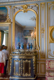 <center>Le château de Chantilly. </center> Salon de Guise. Les dessus de portes sont décorés de toiles représentant le château de Chantilly au temps du Grand Condé. Armoire-bahut en palissandre et ébène, ornée de bronze.