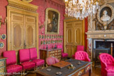 <center>Le château de Chantilly. </center> Le  salon de Condé (Salon du duc). Dans cette pièce ont  été réunis  divers  portraits  des princes  et des princesses de la maison  de Bourbon-Condé. Pour ce salon, qui servait de bureau au duc d’Aumale, Eugène Lami s’est mesuré au XVIIe siècle, l’époque du Grand Condé. Tout y évoque le luxe louis-quatorzien : le damas de soie cramoisi rehaussé de lambrequins tapissant les murs, la dorure des sièges aux accotoirs en crosse et aux lourds piètements. Mais à ces sièges de style Louis XIV se mêlent des fauteuils capitonnés qui n’apparaissent que dans les années 1840. Au-dessus de la porte, le médaillon en tapisserie d'Henri IV.