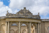 <center>Chantilly. Les grandes écuries. </center> Le portique courbe ionique du manège découvert, sommé d'un frontispice aux armes des Condé, trois fleurs de lis avec le bâton, symbole de la branche cadette de la maison de Bourbon.