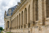 <center>Chantilly. Les grandes écuries. </center> Le pavillon central, à pans coupés et dont le vaste portail est encadré de pilastres, présente un fronton semi-circulaire et s'orne du haut relief exécuté par Bridault représentant des chevaux hennissants.