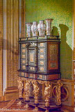 <center>Chambre du Roi. </center> Important cabinet en marqueterie d'étain et d'ivoire sur fonds d'ébène, décoré de plaques de pierres paysagères. Le centre, coiffé d'un fronton supporté par deux colonnes, sépare deux séries de 5 tiroirs chacune. La base de ce cabinet précieux comporte 3 tiroirs soutenus par 4 torses 
