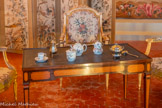 <center>L’exotisme comme art de vivre à la française au temps des Lumières</center>Thé et café
L’apparition dans la société française la seconde moitié du XVIIIe siècle du café, du thé et du chocolat suscite la création de nouveaux récipients pour les contenir et les servir. Le thé est importé en Europe par la Compagnie des Indes orientales mais n’est connu en France et en Angleterre que vers le milieu du XVIIIe siècle ; il faut attendre l'anglomanie de la fin du siècle et du début du XIXe pour que sa consommation soit généralisée. Arrivé à Marseille vers 1640, le café se répand, en revanche, très rapidement en Europe. Cet engouement entraîne l’ouverture d’établissements spécialisés de pourrait les « cafés ». Mal défini au XVIIe siècle, les formes des théières et des cafetières se précisent au siècle suivant. Les premières gardent la forme ronde et basse héritée de l'Orient tandis que les secondes reçoivent une forme plus haute et allongées avec un bec verseur situé près du col. La distinction entre ces deux verseuses est cependant parfois difficile à établir. <br> Table à jeu.
France.
Fin XVIIIe siècle. Acajou, amarante, citronnier, cuir.
Paris, dépôt du Musée des Arts Décoratifs
