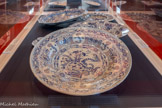 <center>Plat circulaire à décor chinois</center>Marseille, fabrique Saint-Jean-du-Désert 1681.
Faïence stannifère, décor de grand feu en camaïeu de bleu et violet sur fond d’émail bleuté.
Ancienne collection Ernest Leroux, 1896.
Sèvres, Manufacture et musée nationaux.
Le décor de cette pièce, marquée au dos « Marseille 1681 », réalisée donc très tôt dans la production marseillaise, réunit plusieurs éléments décoratifs d’inspiration orientale '.feuilles de bananier, chrysanthèmes, lotus, pivoines, lingzhi (champignon symbolisant l’immortalité), objets sacrés de lettrés (...) seront utilisés isolément sur de nombreuses œuvres des vingt premières années de production de la fabrique de Saint-Jean-du-Désert.