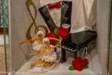 <center>Cordes-sur-ciel. Le musée des Arts du sucre et du chocolat</center>Virtuose.
Il ne manque que le son. Le piano, la clé de Sol et la veste de costume sont en pastillage. Pureté et harmonie. Trois teintes pour un hommage ponctué d'un trio de roses rouges réalisées en sucre tiré. La danseuse est en sucre soufflé habillé d’isomalt.
Temps de réalisation : 20 h