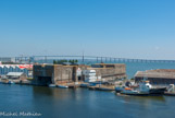 <center>Saint-Nazaire. </center> L'écluse fortifiée de 155 mètres de long, 25 de large et 14 de haut est construite en 1943-1944 dans l'axe de la base de sous-marins. Les terrasses de la base et de l'écluse sont dotées d'une importante défense anti-aérienne. Ce porche de béton permet de protéger les sous-marins des bombardements pendant la période d'éclusage entre l'estuaire et le bassin.