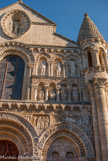 <center>Notre-Dame-la-Grande. </center> Au-dessus de l'arcature aveugle de droite on trouve les personnages du Nouveau Testament, de gauche à droite : La Visitation, la Vierge Marie visite sa cousine Élisabeth
; La Nativité, la Vierge Marie allongée, l'Enfant Jésus, le boeuf et l'âne
; Le bain de l'enfant Jésus
; Saint Joseph
; Deux personnages qui s'embrassent ou luttent.
