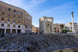 <center>Lecce.</center>La construction de cet amphithéâtre romain remonte aux premières décennies du IIe siècle apr. J.-C, sous les empereurs romains Trajan ou Hadrien. A l'époque, l'amphithéâtre pouvait accueillir près de 25 000 spectateurs. Pour le moment, les fouilles ont permis de dégager une partie de l'arène et des gradins inférieurs avec les portes d'accès et une section de l'enceinte extérieure, le reste se trouvant encore (et pour longtemps) sous les fondations de divers bâtiments, dont la chapelle Santa Maria délia Grazia, de l'autre côté de la rue.