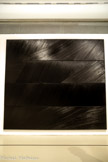 <center>Peinture 324 x 362 cm (Polyptyque J) 1987</center>Huile sur toile
Lausanne, musée cantonal des Beaux-Arts, don de Pierre Soulages en hommage à Olivier Pauli, 2 <br> Débutée en 1985, la grande série de polyptyques allant de A à J est présentée dans son ensemble au musée Saint-Pierre de Lyon en 1987. Entièrement tendue sur câbles, parfois dos à dos, ou habillée au revers d’une plaque de médium blanc, elle expérimente dans un même format les variations lumineuses induites par l’intervention de divers outils sur la matière. Concluant cette série, cette œuvre, dont l’espace de la toile est occupé par un rythme de sillons, interrompu par la césure des châssis, ouvrira en 1990, dos à dos avec le Polyptyque C, l’exposition « Polyptyques :
Le tableau multiple du Moyen-Âge au XXe siècle » au Musée du Louvre. Donnée au musée de Lausanne en 2017, celle-ci a longtemps appartenu à Alice Pauli, grande mécène et soutien de l’art contemporain à travers sa galerie, qui exposera notamment Soulages dès la fin des années 1980.