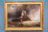 <center>Le Mont-saint-Michel sous l'orage</center>Gudin, Théodore
Pans 1802 - Boulogne-Seine. 1880.
1830
Huile sur toile
Dans cette vue spectaculaire du Mont-Saint-Mi¬chel, Théodore Gudin exalte les forces sauvages d’une nature hostile et la beauté sombre de l’architecture gothique. Ce paysage roman¬tique, fortement inspiré de la peinture hollan¬daise du XVIIe siècle, évoque également l’intérêt croissant, dans les années 1830, pour les monuments nationaux. Jouant sur les échelles, l’artiste confronte la petitesse des fi¬gures et la démesure de l’abbaye, offrant une vision sublime du site.