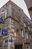 <center>Perpignan</center>A l’angle de la rue Voltaire et de la rue des cordonniers, cette maison aujourd'hui très transformée laisse deviner ses façades originelles du 14e siècle. À l'étage principal, souligné par un cordon mouluré, de grandes baies triples devaient être garnies de fines colonnettes et de chapiteaux sculptés : il n'en reste que des éléments fragmentaires en pierre de taille. Au rez-de-chaussée, la structure de la boutique est intacte, avec ses linteaux en bois et ses arcs de décharge en briques. II faut sans doute voir dans cette maison la demeure d'un marchand du «beau Moyen-Age ».