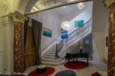 <center>Hôtel C2. </center> Second vestibule avec le grand escalier. L'Hotel C2 occupe une demeure de caractère du XIXe siècle dotée d'un piano à queue. Il en a conservé le marbre, le parquet, les colonnes, les bas-reliefs, les fresques et les rampes en bronze d'origine, qu'il a alliés à une décoration contemporaine minimaliste.