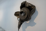 Sans titre
2000, plastique (polypropylène)
Musée d'Art Moderne, Parts, France
J'ai été conçue pour récupérer vos déchets, être utile à la propreté de l’espace public, au service de toutes et tous, on me brûle souvent lors d'émeutes ou de manifestations, Je suis, je suis™ une poubelle !
Oui, cette sculpture en bas-relief, qui ouvre le parcours de l’exposition, est bien une poubelle en plastique qui a été trouvée ainsi déformée par Anita Molinero dans les rues de Marseille. Cette poubelle fondue, elle l’a trouvée magnifique, ce fut ce qu’elle a appelé un « choc esthétique » ! Elle a simplement réalisé un trou central qui semble former une bouche qui crie, comme une colère.
Modeste ou géante, jaune, rouge ou verte, combinée, assemblée, fondue, étirée, suspendue seule ou en grappe, depuis cette rencontre à Marseille, la poubelle a pris une place à part entière dans la sculpture de l’artiste. A tel point qu’elle est devenue comme un objet « signature » d’Anita Molinero.
Musée d’Art Moderne, Paris, France.