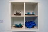 Kallax, 2024.
Étagère Ikea®, petites sculptures (plastique, métal, goudron)
Courtesy de l’artiste et de la Galerie Christophe Gaillard, Paris, France
Kallax porte le nom d’un célèbre modèle d’étagère Ikea®. Produite à l’occasion de l’exposition, cette œuvre joue avec les codes muséographiques en particulier des musées de sciences naturelles. Si ces assemblages rappellent les œuvres produites par l'artiste au début des années 1980 composées de matériaux modestes et « pas regardables », tels que le carton, la mousse, ou emballages en tout genre, ils lui permettent de continuer d'explorer les questions formelles que soulève la sculpture : le plein, le vide, le poids, le volume, l’équilibre. Trouvés dans la rue, les fragments qui composent ces objets la fascinent par leurs formes et leur contemporanéité. Certains d’entre eux restent parfois des années dans son atelier avant de trouver leur place dans de nouvelles productions, des « sculptures de cheminée un peu venimeuses »