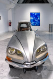 Gabriel OROZCO
1962, Veracruz (Mexique)
La D.S. 1993
Voiture Citroën DS19 de 1970 reprofilée.
Inv. FNAC 94003
Centre national des arts plastiques Dépôt au [mac] musée d'art contemporain de Marseille.
Vit et travaille à New York (États-Unis), Paris (France) et au Mexique
Fils d'un peintre muralista, nourri d'art et d'engagement politique, Gabriel Orozco étudie à l’Escuela Nacional de Artes Plásticas (Mexico) entre 1981 et 1984 puis au Circulo de Bellas Artes (Madrid). Il découvre, lors de son arrivée à Madrid des artistes conceptuels tels Robert Smithson ou Gordon Matta-Clark. Artiste sans atelier, Orozco utilise des carnets de croquis, de photographies et de notes, il met à Jour les relations entre intimité et monde extérieur.
La D.S. est la première pièce d'un ensemble consacré à de véritables mythologies de la circulation urbaine. Elle demeure l'œuvre la plus emblématique d'Orozco : la récupération, l'histoire, le jeu, la sculpture y sont convoqués. Il fait le choix délibéré d'un véhicule futuriste à l'époque de sa conception, qui garde dans l'inconscient collectif une aura d'exception. Quarante ans après son apparition sur les routes françaises, comme voiture présidentielle et dans le cinéma de la Nouvelle Vague, La D.S fait l'objet d'un second design. Le véhicule est découpé en trois morceaux. La partie centrale disparaît les parties latérales sont assemblées l'une avec l'autre. L'impression de vitesse est accentuée, mais, sans moteur, la voiture - plus que le symbole d'un déplacement - devient celui d'un instantané, figé. Orozco la soumet à un processus qu'il nomme « extraction et reconfiguration ». Il s'agit d'un geste minimal, pensé, sculptural, presque modeste : le geste de celui qui depuis toujours préfère modifier que créer du neuf.