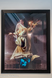 ORLAN
1947, Saint-Étienne (France)
Vierge blanche et noire en Assomption sur moniteur vidéo jouant des pistolets
1983
Photographie tirage cibachrome contrecollé sur aluminium
Inv. FC 748 FCAC, Marseille.
ORLAN, artiste multimédia, utilise son corps comme sujet dès ses toutes premières œuvres. À partir de 1964, l'espace photographique devient le premier lieu du dépassement des limites de son corps. Dès 1968, elle se met en scène dans l'espace urbain. Les Actions ORLAN-CORPS ont toujours fait l'objet d'un enregistrement photographique, vidéographique, ou sonore. Le Baiser de l’artiste (1977) est une action réalisée lors de la FIAC, à Paris : assise derrière une photographie de son buste nu, elle vend des baisers aux visiteurs ou les invite à offrir un cierge à son image en madone. L'installation, qui superpose femme sacrée - sainte ORLAN - et femme objet - ORLAN-CORPS -, fait scandale.
Dans Étude documentaire : le drapé, le baroque (1974-1984), les normes du modèle féminin établies dans la tradition classique y sont transgressées : sculpturale vierge baroque dessinée au gré de lourds drapés plissés, sainte ORLAN se déshabille et au cours du strip-tease occasionnel à l'aide des draps du trousseau, se dévoile jusqu'à la nudité pour devenir ORLAN à la coquille, une Vénus impudique à l'image de celle de Botticelli. Depuis cette action, la figure de sainte ORLAN a fait l'objet d'une longue série d'expériences photographiques et vidéographiques dont fait partie l'œuvre Vierge blanche et noire en Assomption sur moniteur vidéo et jouant des pistolets.